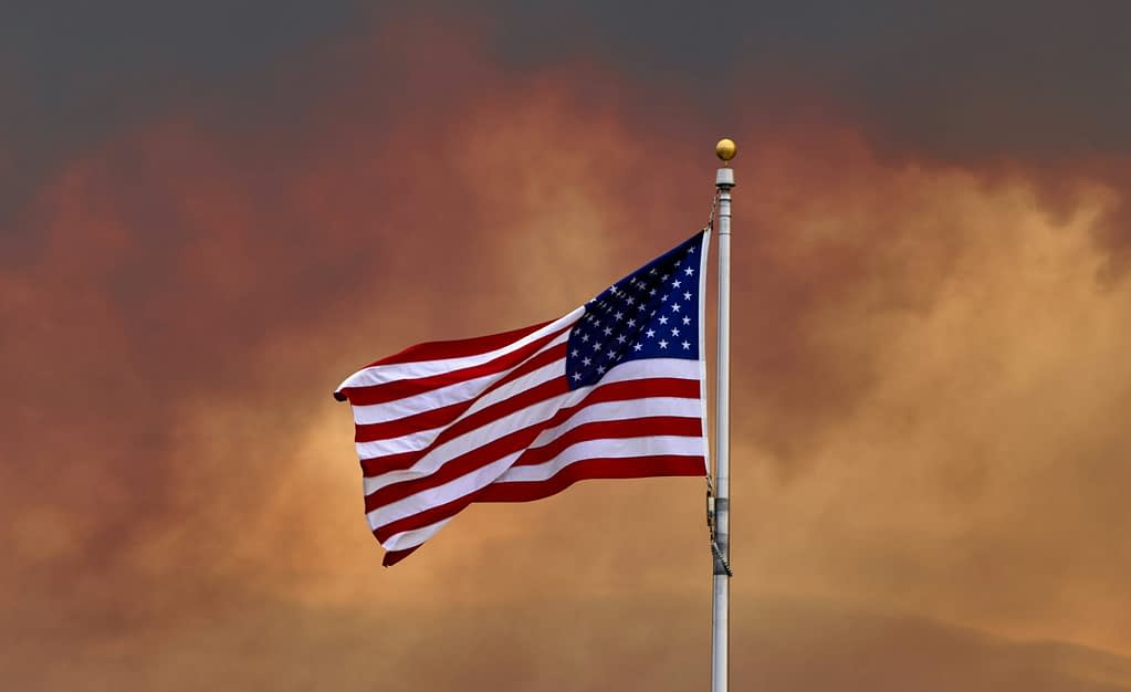 USA tariffs American flag waving against dramatic sky during Trump's new tariffs from 10% to 39% imposed on dozens of countries