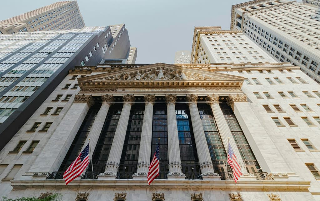 NIQ Global Intelligence IPO at NYSE - New York Stock Exchange building with American flags before billion-dollar market debut