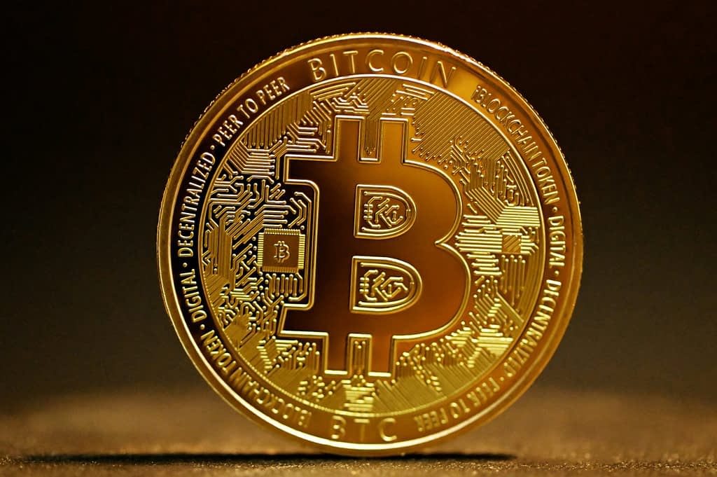 Bitcoin A gold coin with the Bitcoin (BTC) logo on a dark background, representing digital cryptocurrency and blockchain technology.