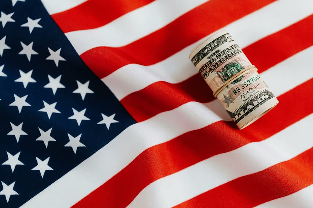 Fed money conflict American flag with dollars symbolizes Trump's political pressure on Fed and central bank over billion-dollar reconstruction