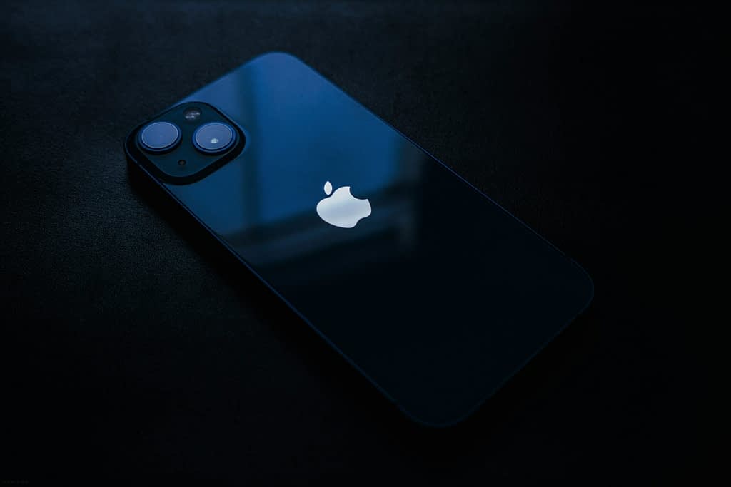 iPhone with Apple logo on dark background symbolizing $600 billion investment due to Trump tariffs and trade war