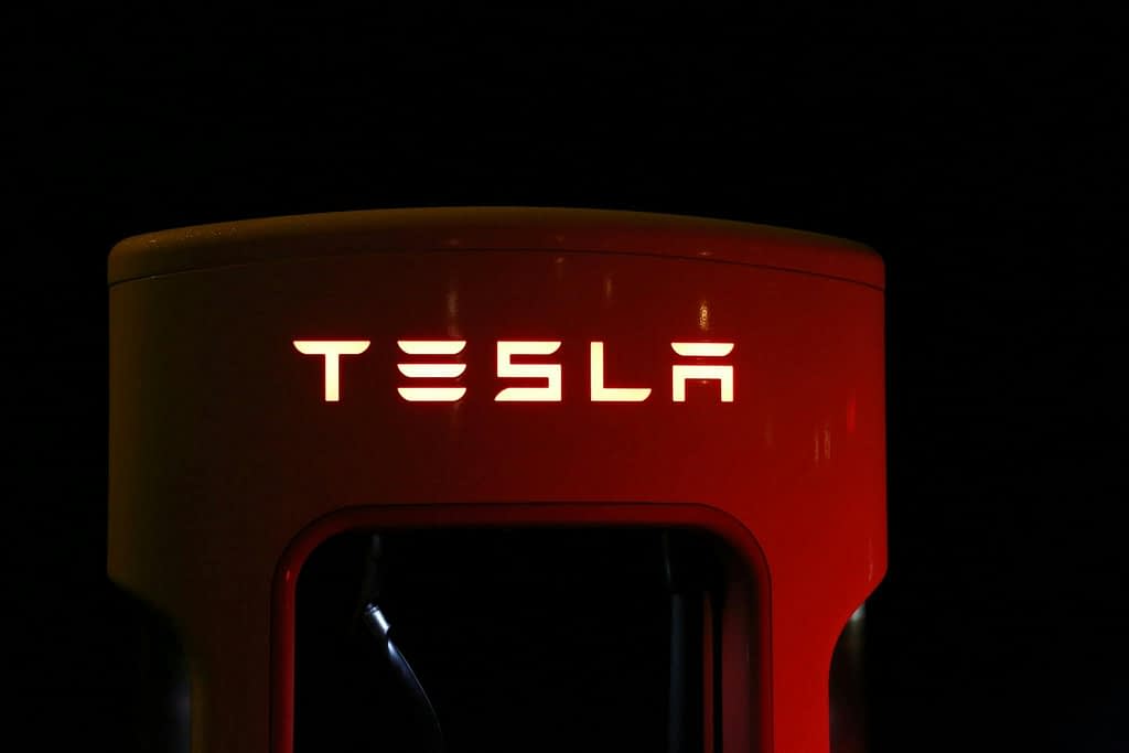 Tesla logo on a red and black background.