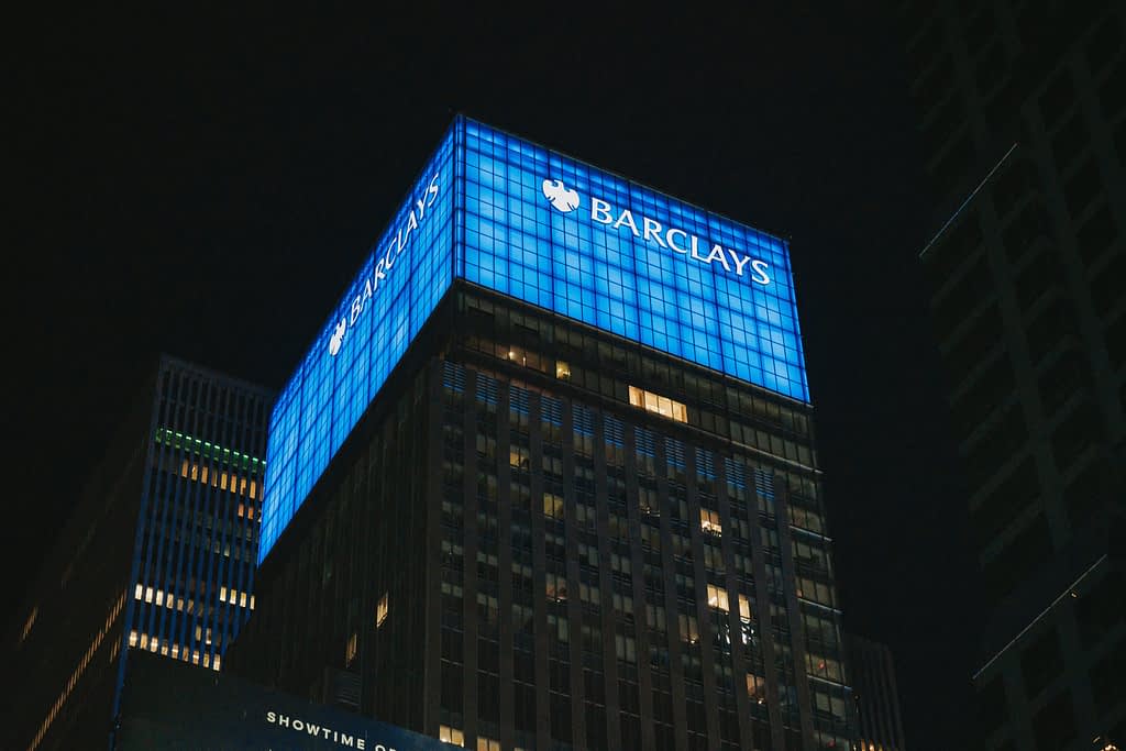 Barclays bank building with blue illumination at night after record Q2 2025 financial results from Trump tariffs