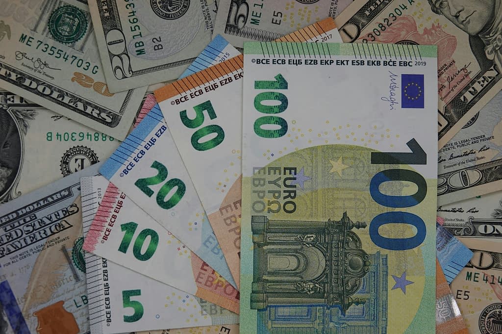 Euro and dollar banknotes spread on table - symbol of competition between European and American currency in global financial system