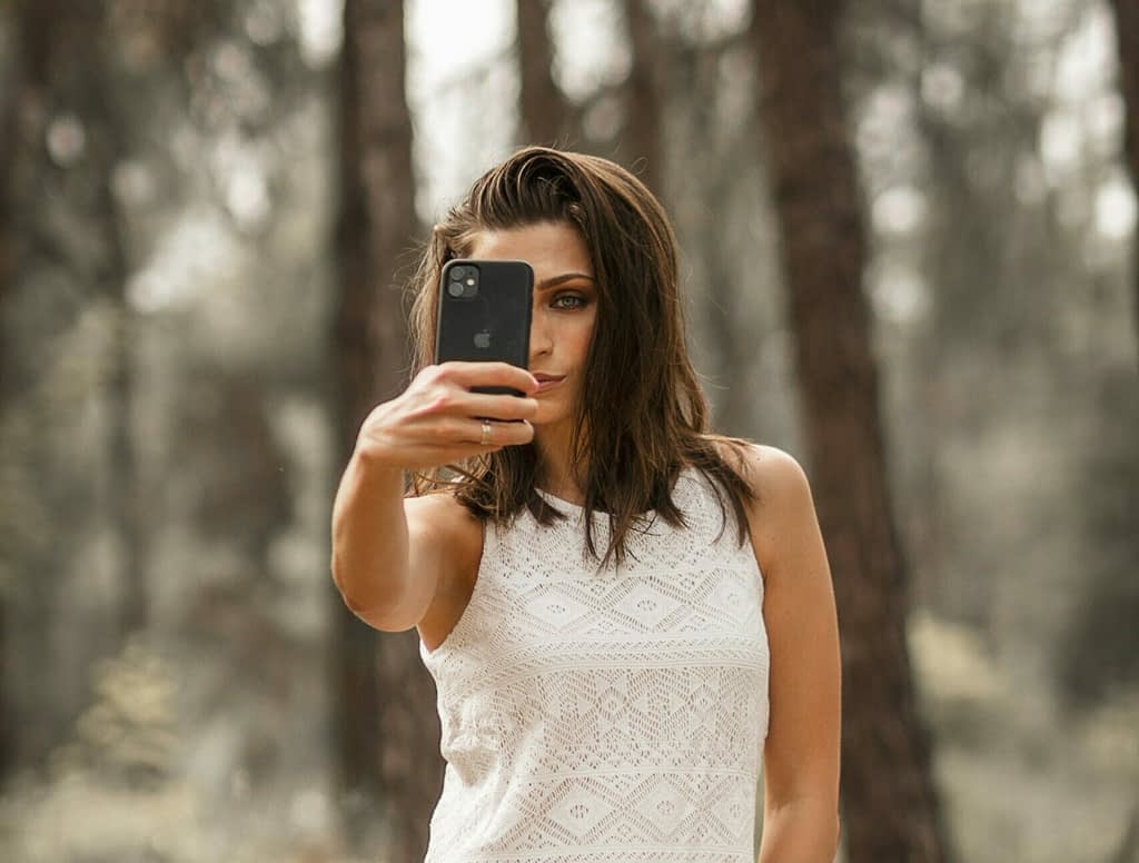 Female content creator Young woman taking selfie with smartphone outdoors - content creation and social media concept.